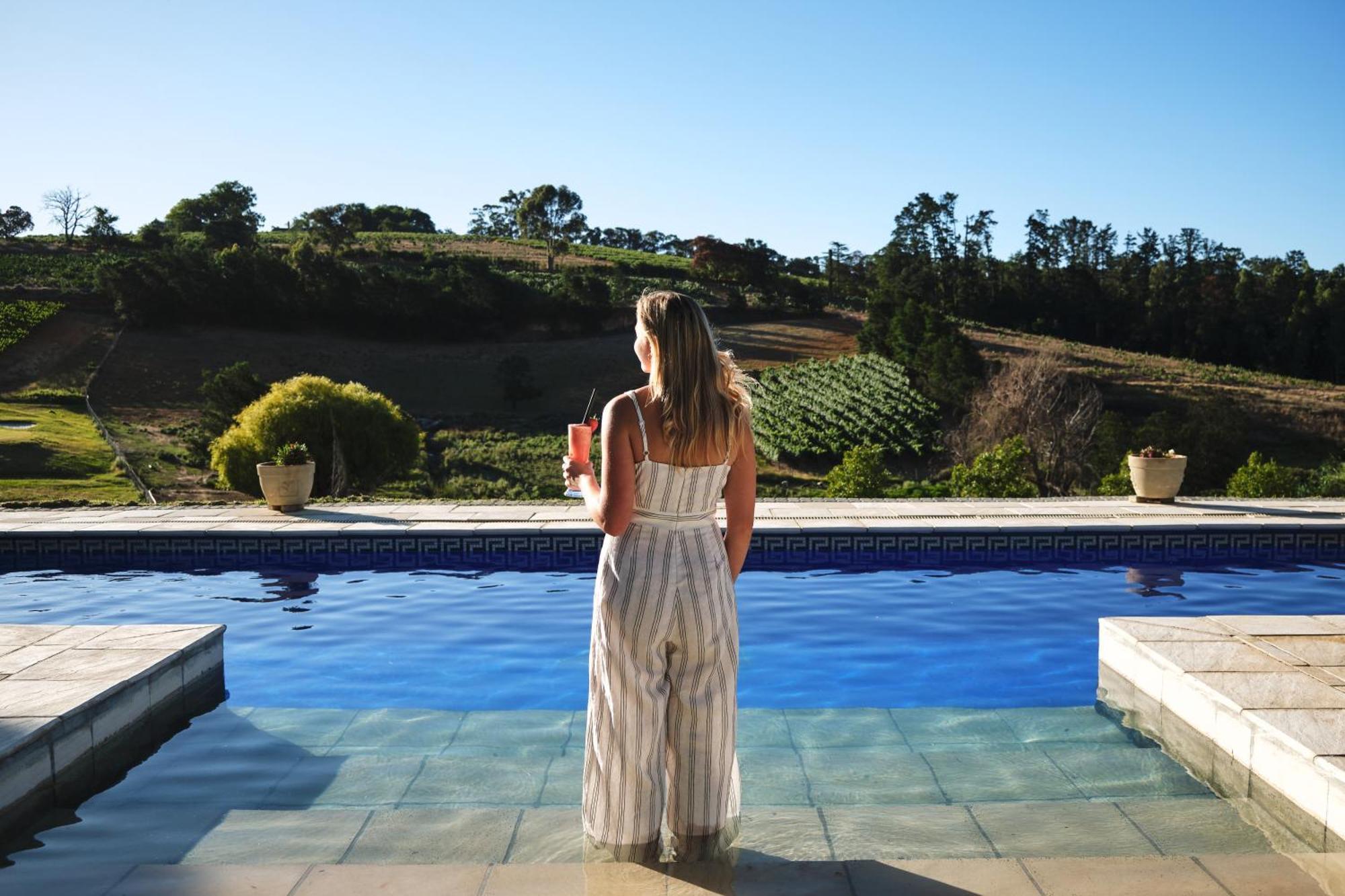 Alluvia Boutique Winery & Luxury Accommodation Стелленбос Номер фото A woman standing by a pool